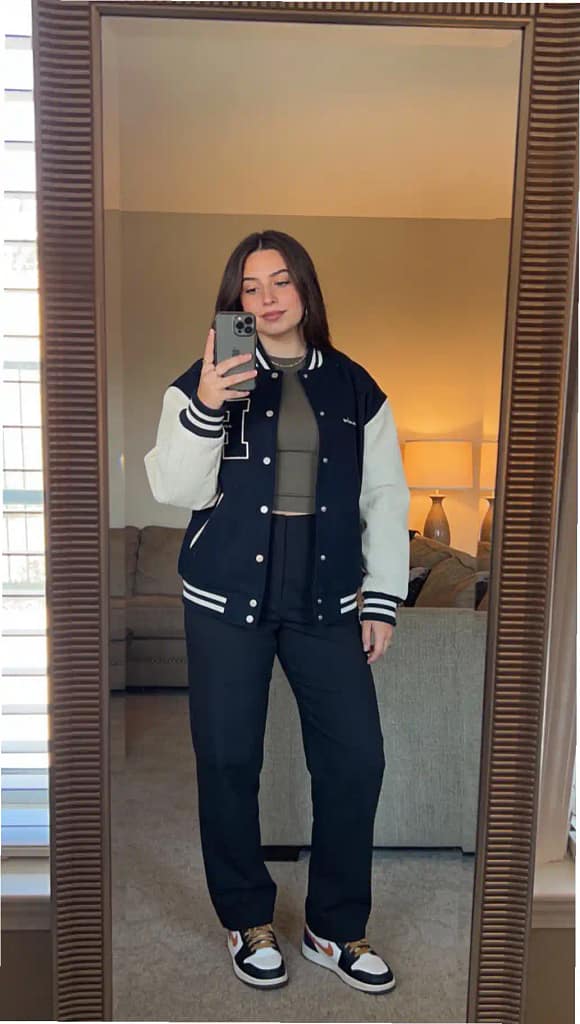 Casual street style with navy varsity jacket and black trousers