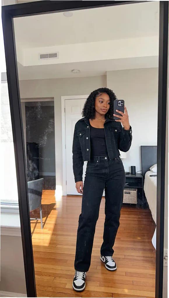 Woman wearing a chic all-black denim jacket and jeans